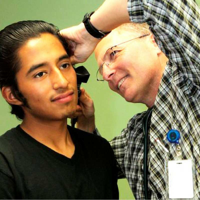 doctor examine young man's ear
